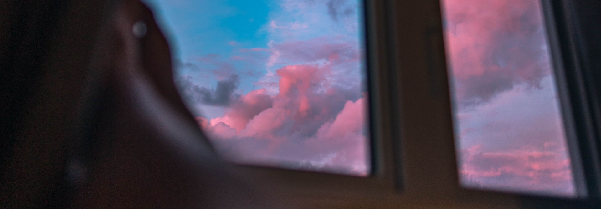Impressionsbild mit Fensteraussicht auf einen bewölkten Himmel in der Dämmerung